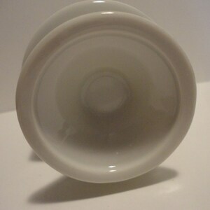 May include: White ceramic pedestal with a round base and a smooth, glossy finish.