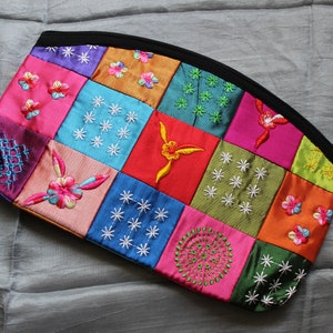 Bolsa de seda con bordado intrincado, detalles de patrón tipo colcha y cuentas; forro superior negro e hilos multicolor; hecho en Vietnam.