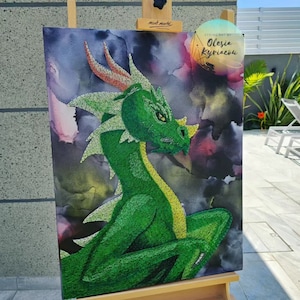 Puede incluir: Arte de hilo de dragón verde sobre un lienzo con fondo de acuarela. El arte está en un caballete y tiene un letrero que dice "String Art by Olesia Kyriakov".