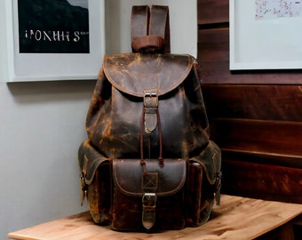 May include: A brown leather backpack with a distressed look. It has a large main compartment, two front pockets, and adjustable straps.