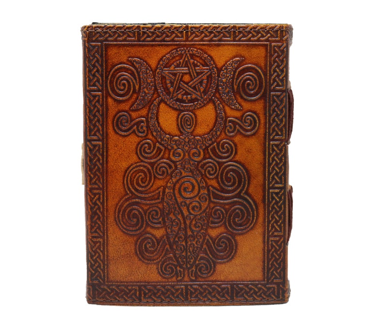 Handmade Brown Genuine leather bound journal Book of shadows grimoire featuring Triple Moon emboss, secured with swing clasp closure, showing blue stone ideal as spell book, travel dairy, rustic guestbook, rest on vintage table with a pen.