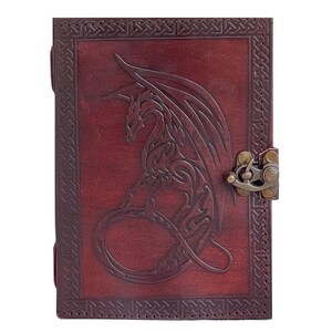Handmade Refillable tan Brown Premium leather bound journal Magic mystical feature dragon embossed, secured with brass polish metal clasp closure, ideal spell book, travel diary, rustic guest book, rest on vintage table with pen.
