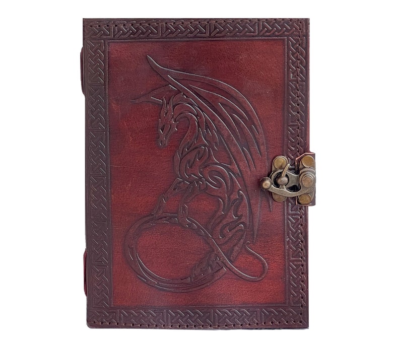 Handmade Refillable tan Brown Premium leather bound journal Magic mystical feature dragon embossed, secured with brass polish metal clasp closure, ideal spell book, travel diary, rustic guest book, rest on vintage table with pen.