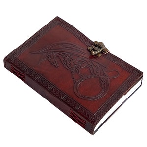 Handmade Refillable tan Brown Premium leather bound journal Magic mystical feature dragon embossed, secured with brass polish metal clasp closure, ideal spell book, travel diary, rustic guest book, rest on vintage table with pen.