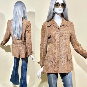 Pode incluir: Uma jaqueta marrom com estampa de pele de cobra, fechamento com botões e mangas compridas. A jaqueta tem um cinto na cintura e dois bolsos na frente.