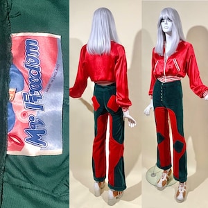 May include: A retro two-piece outfit displayed on a mannequin. The set features a red satin bomber jacket with white stripes and green and red velvet trousers. The trousers have a distinctive colour-block design. The label reads "Mr. Freedom, Made in England."