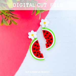May include: A pair of watermelon slice earrings with a white flower charm. The earrings are red, green, and black with a white outline. The earrings are on a white background.