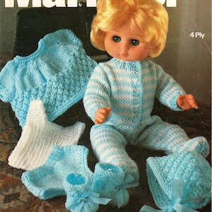 Puede incluir: Un conjunto de punto a rayas azul y blanco para una muñeca, que incluye un gorro, botines y un suéter. La muñeca lleva el conjunto y tiene el pelo rubio y los ojos azules. La imagen es de un libro de patrones de punto.