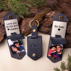 May include: Navy blue leather keychains with personalized photos and text. One keychain reads "Love you till the end cheeks" and another says "Be Safe". The center keychain has initials "K&hearts;S". Each keychain has a metal snap closure.