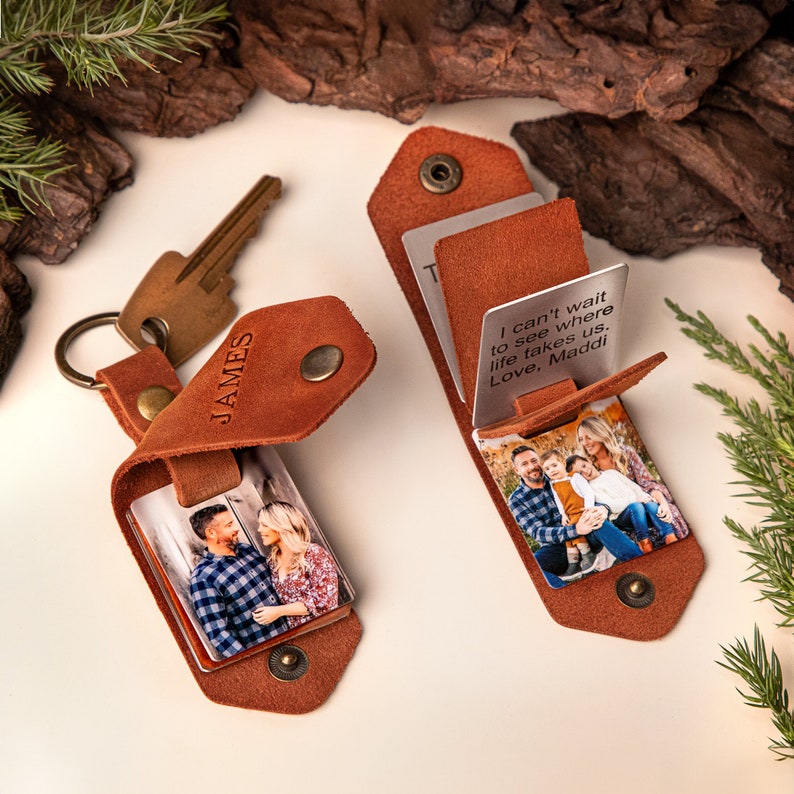 May include: Two brown leather keychains with metal accents, each holding a photo. One keychain is engraved with "JAMES." The other keychain has a photo and a metal card with the text "I can't wait to see where life takes us. Love, Maddi."