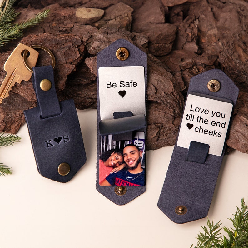 May include: Navy blue leather keychain with embossed initials and a heart. Two navy blue leather cardholders with metal inserts. One cardholder reads "Be Safe" with a heart, the other reads "Love you till the end cheeks" with a heart. Each cardholder has a photo.
