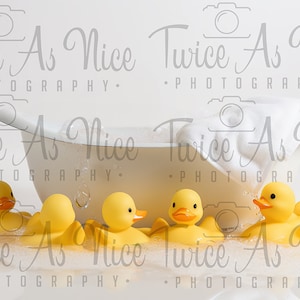 May include: A white bathtub with a white towel draped over the side.  There are several yellow rubber duckies floating in the tub and on the edge of the tub.  The background is white.