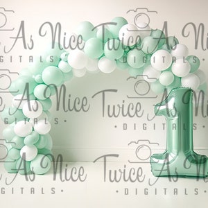 Puede incluir: Un arco de globos verde y blanco con un gran globo número uno verde delante de una pared blanca. Los globos están dispuestos en forma de semicírculo. El globo número uno está hecho de aluminio y tiene un acabado brillante.