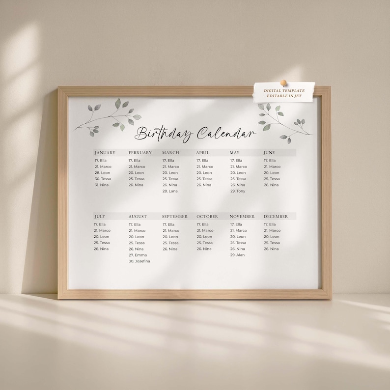 May include: A framed birthday calendar with a light wood frame. The calendar is white with black text, listing names and dates for each month. Decorative leaf illustrations are at the top. The words "Birthday Calendar" are at the top.