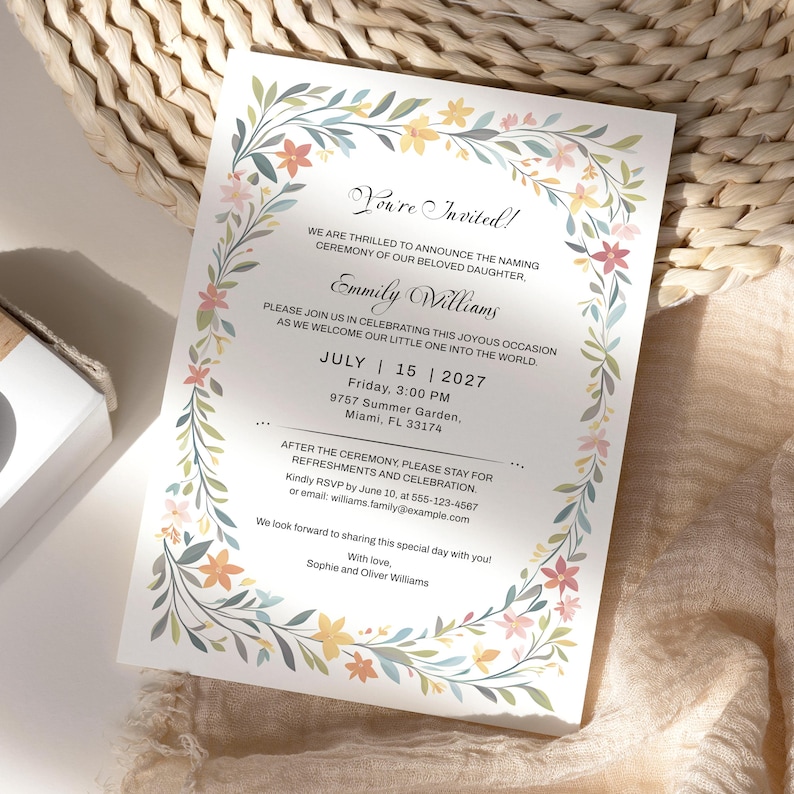 May include: A white rectangular invitation card featuring a floral border with green leaves and small flowers in shades of yellow, orange, and pink. The text announces a naming ceremony for Emmily Williams on July 15, 2027, at 3:00 PM in Miami, FL.