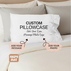 May include: White custom pillowcase with the text "CUSTOM PILLOWCASE Add Your Own Message/Photo/Logo". The design includes arrows pointing to areas for adding a message or photo. The pillowcase is on a bed with neutral-colored bedding.