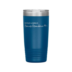 May include: A blue stainless steel tumbler with a white inscription that reads "Nicole & Nora's Bonus Grandma" with a small heart symbol.
