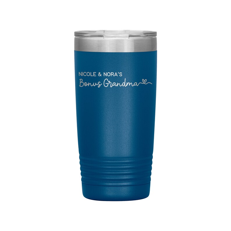 May include: A blue stainless steel tumbler with a white inscription that reads "Nicole & Nora's Bonus Grandma" with a small heart symbol.