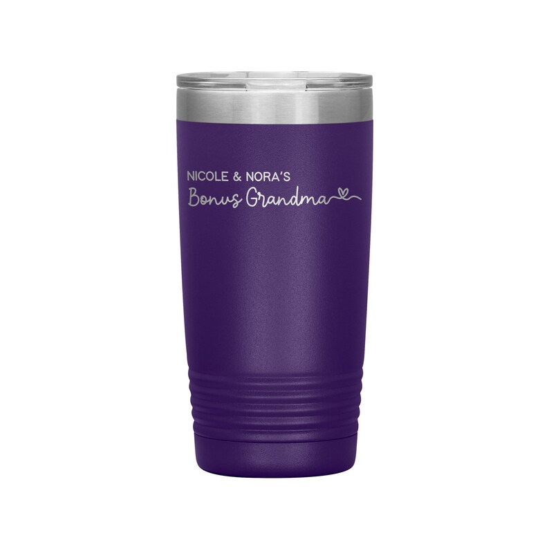May include: Purple stainless steel tumbler with a white inscription that reads "Nicole & Nora's Bonus Grandma" with a heart symbol.