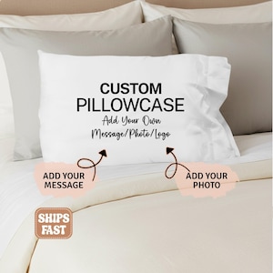 May include: A white rectangular pillowcase featuring the black printed text CUSTOM PILLOWCASE Add Your Own Message/Photo/Logo. Below the text, two black arrows point to light pink brushstroke shapes labeled ADD YOUR MESSAGE and ADD YOUR PHOTO.
