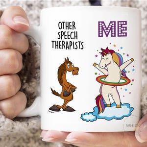 May include: A white ceramic mug featuring a cartoon brown horse labeled Other Speech Therapists and a cartoon unicorn with a rainbow mane playing with a hula hoop labeled ME in purple letters, surrounded by colorful stars and blue clouds.