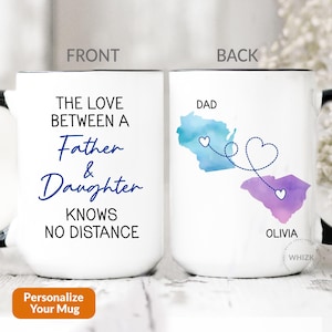 May include: White ceramic mug with black handle and rim. The front reads "THE LOVE BETWEEN A Father & Daughter KNOWS NO DISTANCE." The back features watercolor map outlines with hearts and the names "DAD" and "OLIVIA."