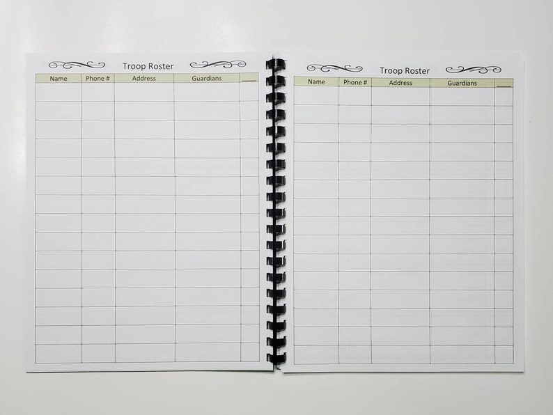 May include: Open spiral-bound notebook with the words "Troop Roster" at the top of each page. The pages are divided into columns labeled "Name," "Phone #," "Address," and "Guardians." The notebook is open, displaying two facing pages with a grid of blank lines.