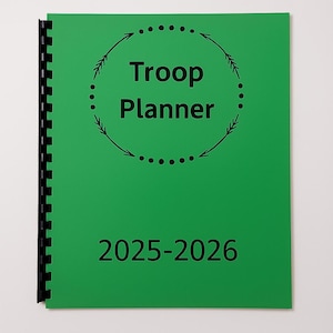 May include: A green spiral-bound planner with the words "Troop Planner" in black, encircled by a dotted line with arrows. The year range "2025-2026" is printed below. The planner is designed for organizing troop activities.
