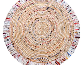 Op de afbeelding: Rond jute vloerkleed met een spiraalvormig ontwerp. Het vloerkleed heeft een natuurlijke beige kleur met kleurrijke accenten van rood, blauw en wit. De rand is afgewerkt met een franje, wat textuur toevoegt. Geschikt voor diverse interieurstijlen. Diameter 120 cm.