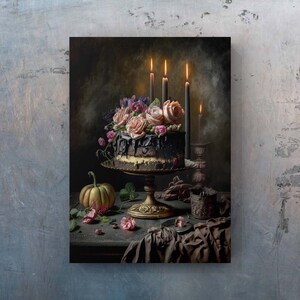 May include: A dark chocolate cake decorated with pink and purple flowers, topped with a black chocolate ganache, and surrounded by lit candles. The cake is on a gold stand and a small pumpkin sits on the table next to it.