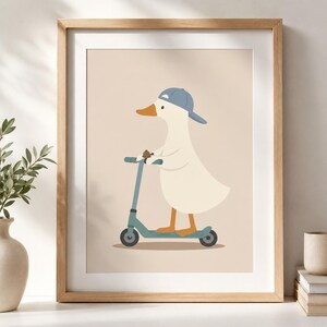 May include: A framed wall art print featuring a white duck wearing a blue baseball cap and riding a teal kick scooter. The duck has an orange beak and orange feet, and it is holding a small brown object while standing on the scooter deck.