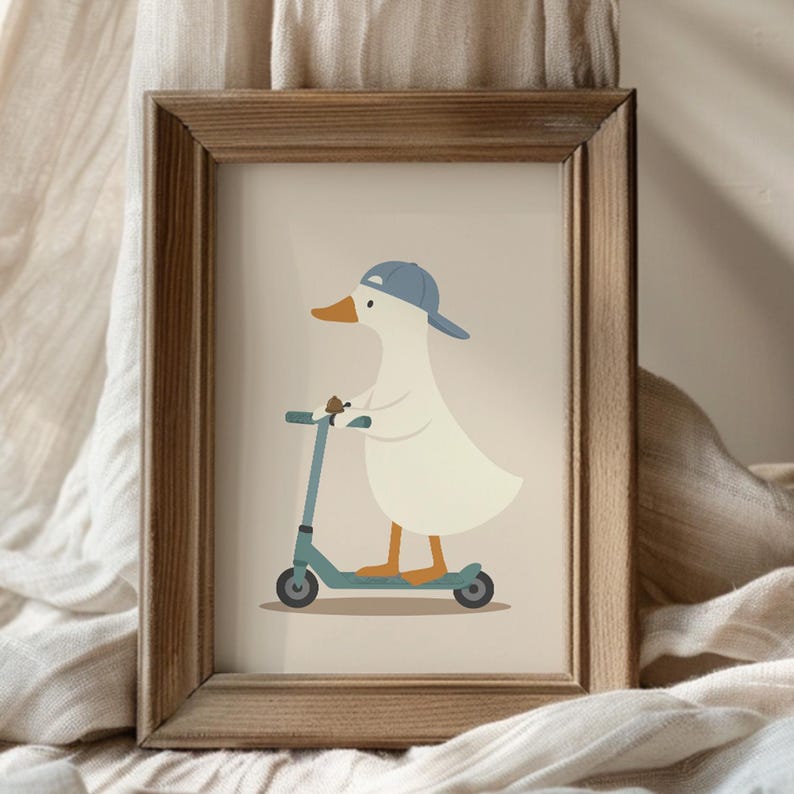 May include: A framed art print featuring a white duck wearing a blue baseball cap and riding a teal kick scooter. The illustration is set against a light beige background and is enclosed in a simple, rectangular wooden frame with a natural finish.
