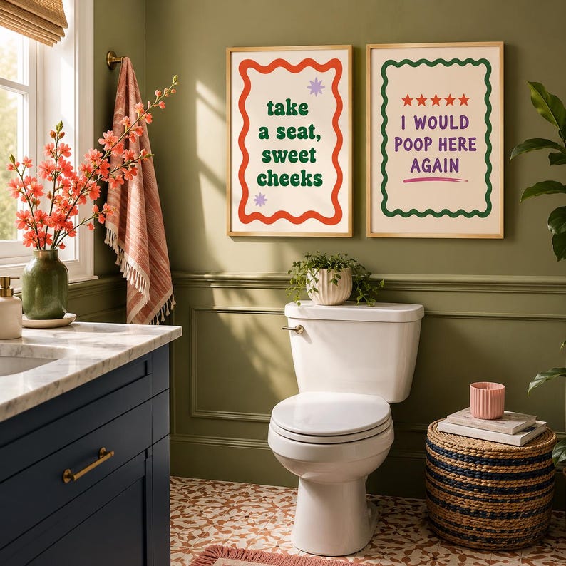 Op de afbeelding: Twee rechthoekige wandposters in licht houten lijsten. De linker poster heeft een golvende rode rand, groene tekst met "take a seat, sweet cheeks" en twee kleine paarse sterren. De rechter poster heeft een golvende groene rand, vijf rode sterren en paarse tekst met "I WOULD POOP HERE AGAIN" met een roze onderstreping.