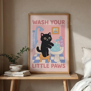 Può includere: Un poster illustrato rosa e blu con un gatto nero che fa il bagno in una vasca da bagno. Il poster dice "Lava le tue piccole zampe" in testo bianco.
