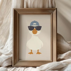 May include: Framed art print featuring a cartoon duck wearing sunglasses and a blue baseball cap. The duck has an orange beak and feet, set against a neutral background. The wooden frame adds a rustic touch.