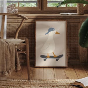 May include: A framed print featuring a cartoon duck wearing a blue baseball cap and riding a skateboard. The duck is white with an orange beak and feet. The skateboard is black with orange wheels, set against a beige background.