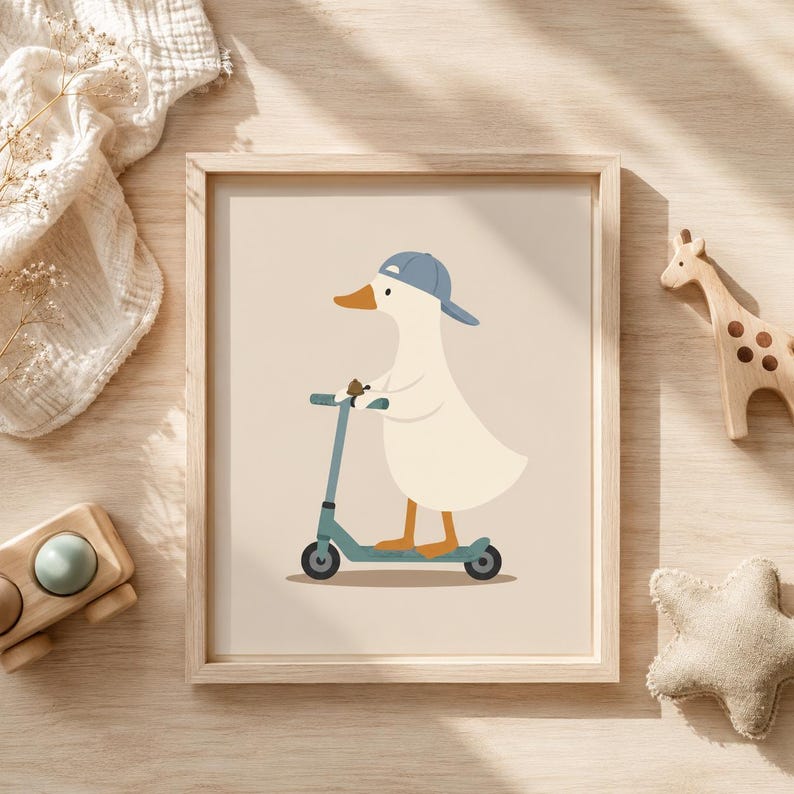 May include: A framed wall art print featuring a cream-colored duck wearing a blue baseball cap while riding a blue kick scooter. The illustration is set against a solid light beige background, presented in a simple light-toned wooden frame.