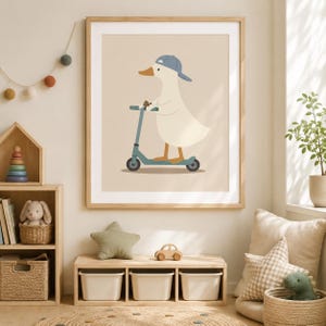 May include: A framed wall art print featuring a white duck wearing a blue baseball cap and riding a teal kick scooter. The illustration is set against a solid beige background, showcasing clean lines and a simple, flat graphic design style.