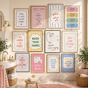 May include: A gallery wall of twelve rectangular framed prints featuring colorful bathroom-themed illustrations and text, including phrases like take a seat, guest check, splash splash, shower karaoke, wash your hands, and I would poop here again.