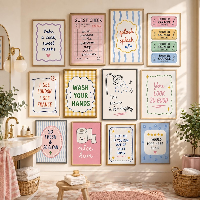 May include: A gallery wall of twelve rectangular framed prints featuring colorful bathroom-themed illustrations and text, including phrases like take a seat, guest check, splash splash, shower karaoke, wash your hands, and I would poop here again.