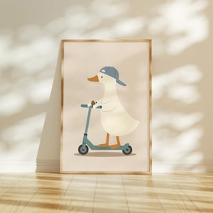 May include: A framed wall art print featuring a cartoon illustration of a white duck wearing a blue baseball cap while riding a teal kick scooter. The duck has an orange beak and orange feet, set against a solid light beige background.