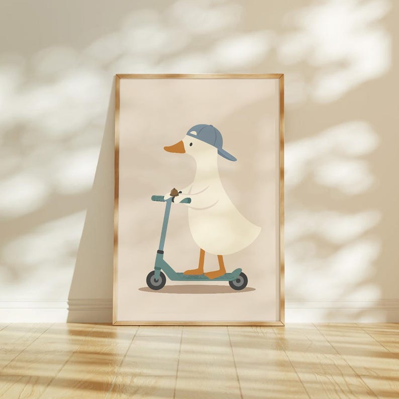May include: A framed wall art print featuring a cartoon illustration of a white duck wearing a blue baseball cap while riding a teal kick scooter. The duck has an orange beak and orange feet, set against a solid light beige background.