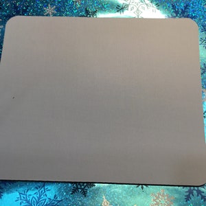 Puede incluir: Un ratón gris liso con una superficie ligeramente texturizada.