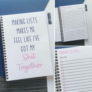 May include: A white spiral-bound notebook with the text "MAKING LISTS MAKES ME FEEL LIKE I'VE GOT MY Shit Together" in blue and pink. The notebook has a "THINGS TO DO" page with checkboxes and sections for reminders and notes.