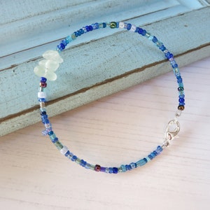 Dainty bracelet with three pieces of Cornish sea glass surrounded by tiny blue glass beads and fastened with a silver plated lobster catch.