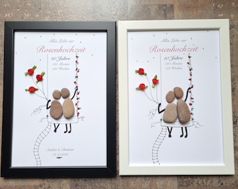 May include: Two framed prints with a white background and black and white line drawings of a couple on a swing. The couple is made of small stones. The text on the prints reads "Alles Liebe zur Rosenhochzeit 10 Jahre 120 Monate 621 Wochen" and "Sindre & Christian 12.10.2012".