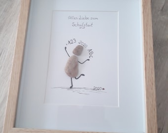 May include: A framed picture with a hand-drawn illustration of a person made of stones. The person is holding a sign that says "123" and "ABC". The picture also includes the text "Alles Liebe zum Schulstart" and "2020".
