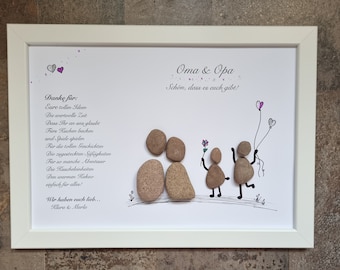 May include: A framed white card with a handwritten message thanking Oma & Opa for their love and support. The message is written in German and includes a drawing of a family made of stones. The card is decorated with small pink hearts.