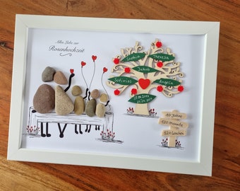 May include: A framed artwork with a white background and a hand-drawn illustration of a couple sitting on a bench with three children. The couple is represented by two large stones, and the children are represented by smaller stones. There is a wooden tree with red hearts and green leaves, with the names "Sophia", "Sotirios", "Jakob", "Theresa", and "AngeCa" written on the leaves. The tree also has a red heart with the dates "25.06.2014" and "25.04.2009" written on it. There is a wooden sign with the text "10 Jahre", "120 Monate", and "521 Wochen" written on it. The artwork is titled "Allen Liebe zur Rosenhochzeit".
