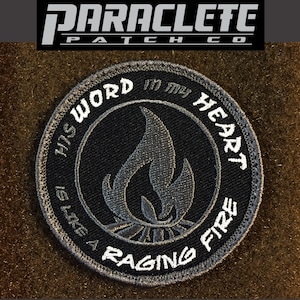 May include: A gray and white embroidered patch with a flame design and the text "His Word in my Heart is like a Raging Fire".